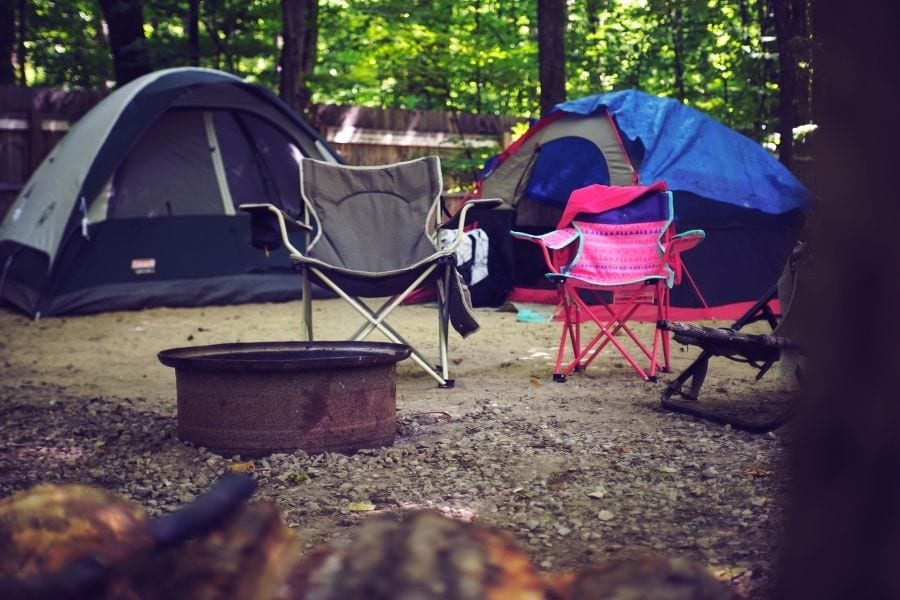 在露营地的火坑周围搭起的野营椅和帐篷