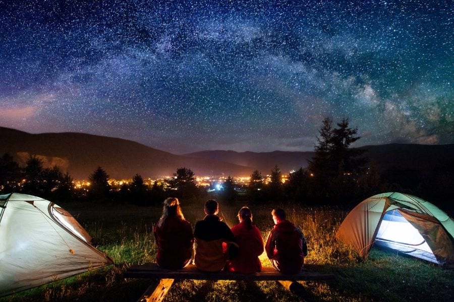 四个朋友在城市附近的露营地看夜空中的星星
