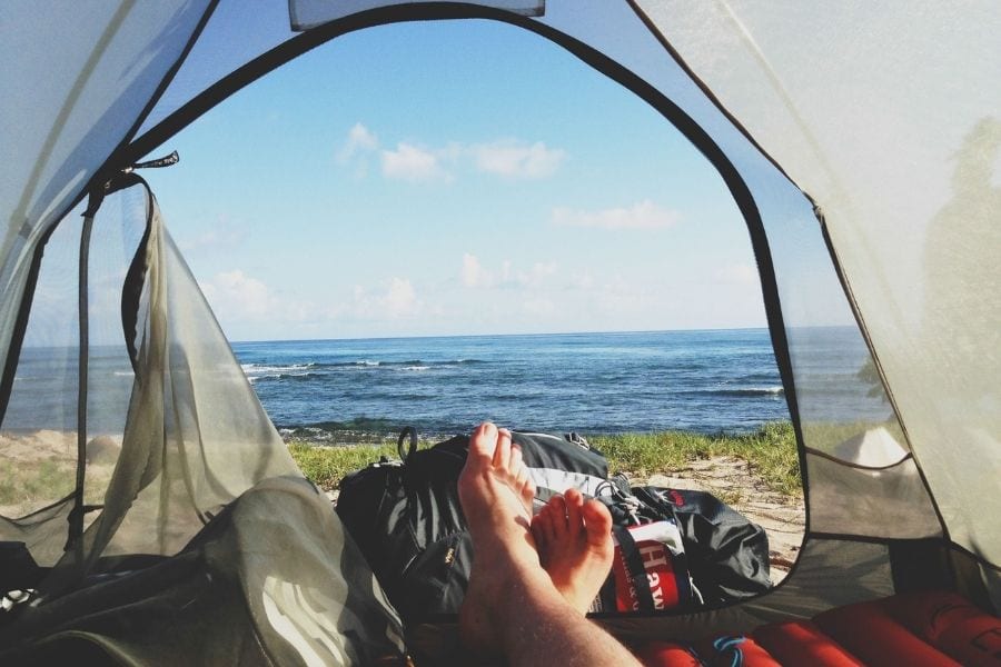 一个露营者躺在面向大海的帐篷里